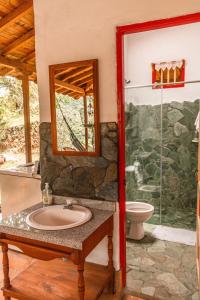 uma casa de banho com um lavatório e uma cabina de duche em vidro. em Cabaña Rustica em Montebello