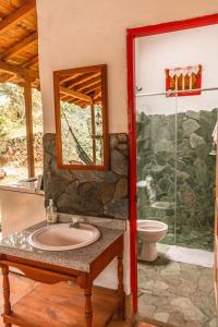 Un baño con lavabo y ducha de cristal. en Cabaña Rustica, en Montebello