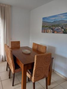 una mesa de comedor con sillas y una pintura en la pared en Apartaments Bell-Lloc Puigcerda en Puigcerdá