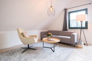 a living room with a couch and a chair and a table at Ferienwohnung Lee Ost 2 3 in Dierhagen