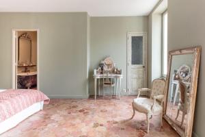 sypialnia z łóżkiem, lustrem i stołem w obiekcie La Demeure Provençale au charme suranné w mieście Nîmes