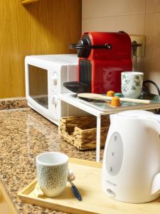 um balcão de cozinha com comodidades para preparar café e um micro-ondas em COSTA AZUL em Puerto de Sagunto