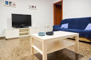 uma sala de estar com um sofá azul e uma mesa em COSTA AZUL em Puerto de Sagunto
