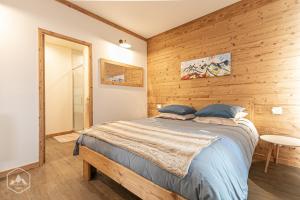 - une chambre avec un lit et un mur en bois dans l'établissement Côté-Bourget, 2 apparts, 10 pers LE BOURGET et 4 pers L'ORGERE, proche La Norma Aussois, à Villarodin-Bourget