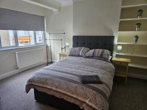 a bedroom with a large bed and two windows at Leigh-on-Sea Retreat - 2 Bedroom Apartment in Leigh-on-Sea