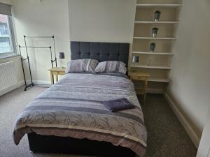 a bedroom with a bed and a desk and shelves at Leigh-on-Sea Retreat - 2 Bedroom Apartment in Leigh-on-Sea