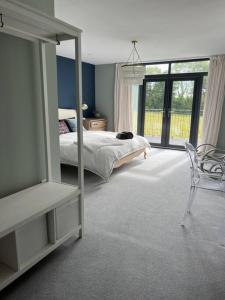 a bedroom with a bed and a mirror and a chair at Stunning home with magnificent views in East Devon in Exeter