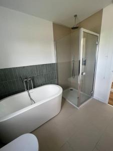 y baño blanco con bañera y ducha. en Stunning home with magnificent views in East Devon, en Exeter