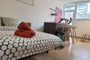 a bedroom with a bed with a red pillow on it at Le zen - Appartement avec terrasse in Vertou