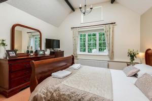 - une chambre avec un lit, une commode et un miroir dans l'établissement New Forest Cottages, à Godshill