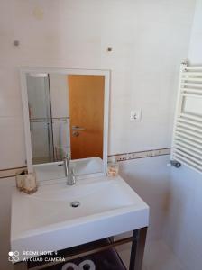een badkamer met een witte wastafel en een spiegel bij Villa Estrelinha in Nazaré