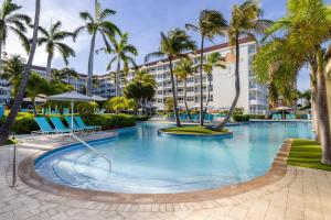 una piscina con palmeras y un edificio en Marriott's Aruba Ocean Club, en Palm-Eagle Beach