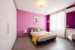 1 dormitorio con paredes de color púrpura y 1 cama en 3 MIN DAL MARE - Aria Condizionata - Parcheggio Privato"CASA DEI COLORI", en Lido di Camaiore