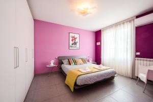 a bedroom with purple walls and a bed at Parcheggio Privato e Aria Condizionata "CASA DEI COLORI" in Lido di Camaiore