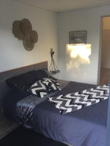 ein Schlafzimmer mit einem Bett mit einer Decke darauf in der Unterkunft Chambre indépendante avec salle de bain in Saint-Paul-et-Valmalle