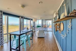 ein Esszimmer mit blauen Wänden sowie einem Tisch und Stühlen in der Unterkunft Beachy Maryland A-Frame Steps to Chesapeake Bay! in Ridge
