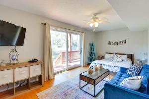 ein Wohnzimmer mit einem blauen Sofa und einem TV in der Unterkunft Beachy Maryland A-Frame Steps to Chesapeake Bay! in Ridge