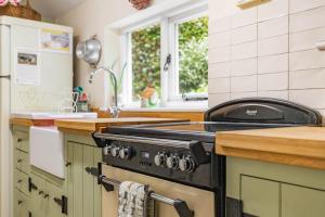 a kitchen with a stove and a counter top at Ships Timbers in Winterton-on-Sea
