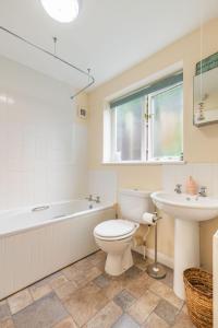a bathroom with a toilet and a sink and a tub at Ships Timbers in Winterton-on-Sea
