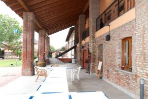 eine Terrasse mit Tischen und Stühlen in einem Gebäude in der Unterkunft Cascina Amrit CAV in Borghetto Lodigiano