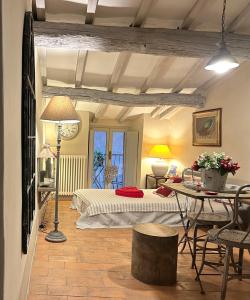 a bedroom with a bed and a table with chairs at Cortona Shabby Chic House in Cortona