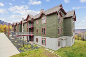 a large green and white building with red windows at Gorgeous views, tastefully decorated Ski on ski off 3 bedroom condo, with sports center access Lodges 303 in Killington