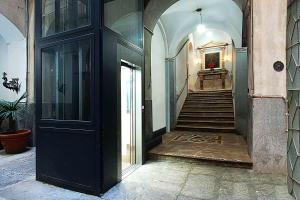 un couloir d'un immeuble avec un escalier et une porte dans l'établissement Maqueda331, à Palerme