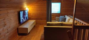 un soggiorno con divano e TV a schermo piatto di Himos, Areenan alue a Jämsä