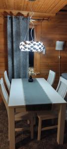 einen Esstisch mit Stühlen und einer Leuchte in der Unterkunft Himos, Areenan alue in Jämsä