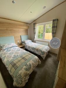 - une chambre avec 2 lits et une fenêtre dans l'établissement The Retreat Hot Tub Lodge - Golden Palm Resort (21), à Skegness