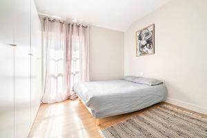 a bedroom with a bed and a large window at Superbe Appartement Intramuros in Avignon