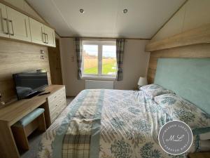 - une petite chambre avec un lit et une télévision dans l'établissement The Retreat Hot Tub Lodge - Golden Palm Resort (21), à Skegness