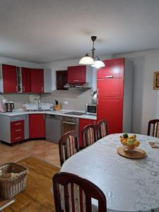 a kitchen with red cabinets and a table with a bowl of fruit at Villa Jasmin - Vlašić in Vlasic