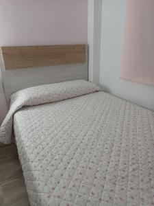 ein Schlafzimmer mit einem Bett mit einer weißen Tagesdecke in der Unterkunft Apartamento de Marta in Miramar