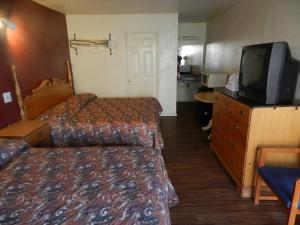 a hotel room with two beds and a flat screen tv at Seagem Motel and Apartments in Seaside Heights