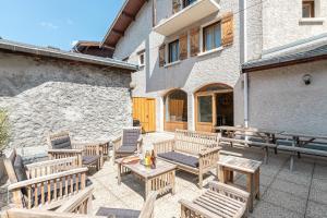 a patio with wooden benches and tables in front of a building at Côté-Bourget, Appartement 10 pers LE BOURGET, proche stations La Norma Aussois in Villarodin-Bourget