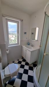 a bathroom with a sink and a toilet and a window at Villa Sea Garden Slano in Slano +50 photos