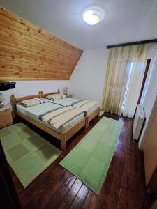 a bedroom with a bed and green rugs at Villa Jasmin - Vlašić in Vlasic