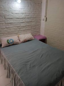uma cama grande num quarto com uma parede de tijolos em ALQUILER TEMPORARIO LU-KA em Presidencia Roque Sáenz Peña