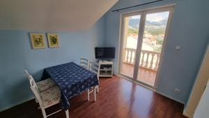 a room with a table and a television and a balcony at Villa Sea Garden Slano in Slano