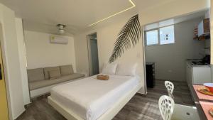 a bedroom with a white bed and a couch at El Morro Beach 2 in Santa Marta +5 photos