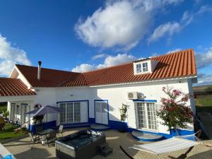 a white house with a red roof and a patio at Quinta Da Amoreira in Ferreira do Alentejo