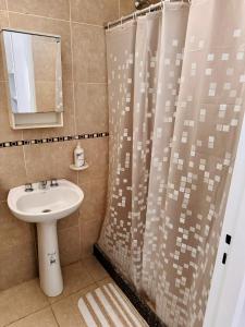 a bathroom with a sink and a shower curtain at Departamento Nórdico San Juan in San Juan