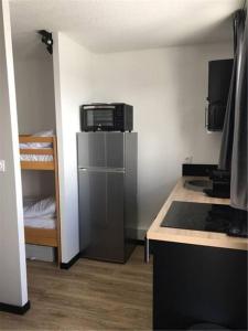 eine kleine Küche mit einem Kühlschrank und einem Herd in der Unterkunft Appartement Vue Montagne in Val Louron