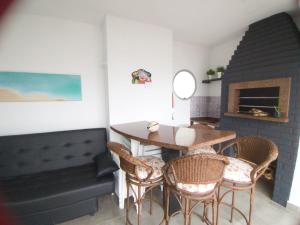 Itapema-Meia Praia- 3 quartos - Frente Mar! في ايتابيما: غرفة طعام مع طاولة وكراسي ومدفأة