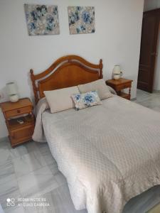 a bedroom with a large bed with two night stands at Apartamentos Almenas in Écija