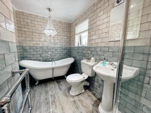 ein Badezimmer mit einem WC, einer Badewanne und einem Waschbecken in der Unterkunft Otterburn House in Rothesay