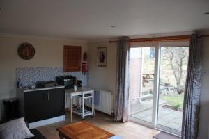 une cuisine avec un comptoir, une table et une fenêtre dans l'établissement 73 Westend, Balallan, Isle of Lewis, à Balallan