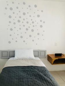 a bedroom with a bed and a wall with gray dots at Casa Tanah in Guadalajara