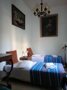 a bedroom with two beds and a table and a chandelier at Mavipagi in Verona